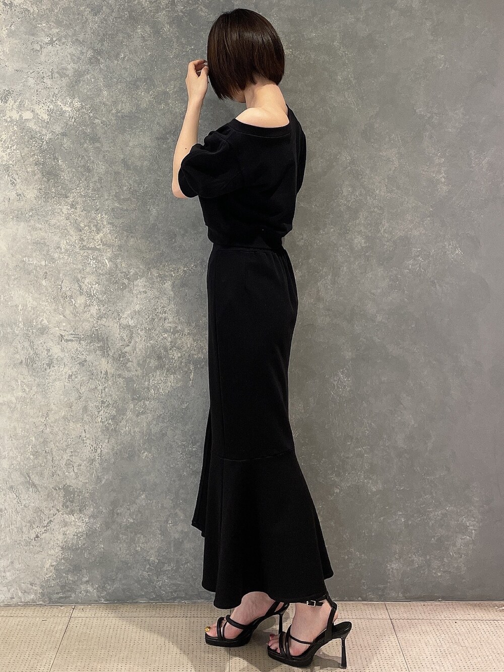 ブラック系のサンダル、ブラック系のスカート、ブラック系のスウェットを着用したレディースの春コーディネートの3枚目の写真