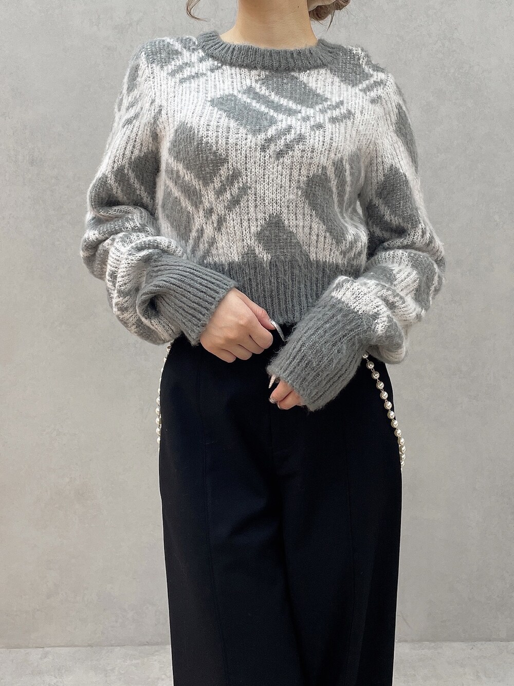 グレー系のニット/セーター、ブラック系のその他パンツ、ブラック系のブーツを着用したレディースの秋コーディネートの7枚目の写真