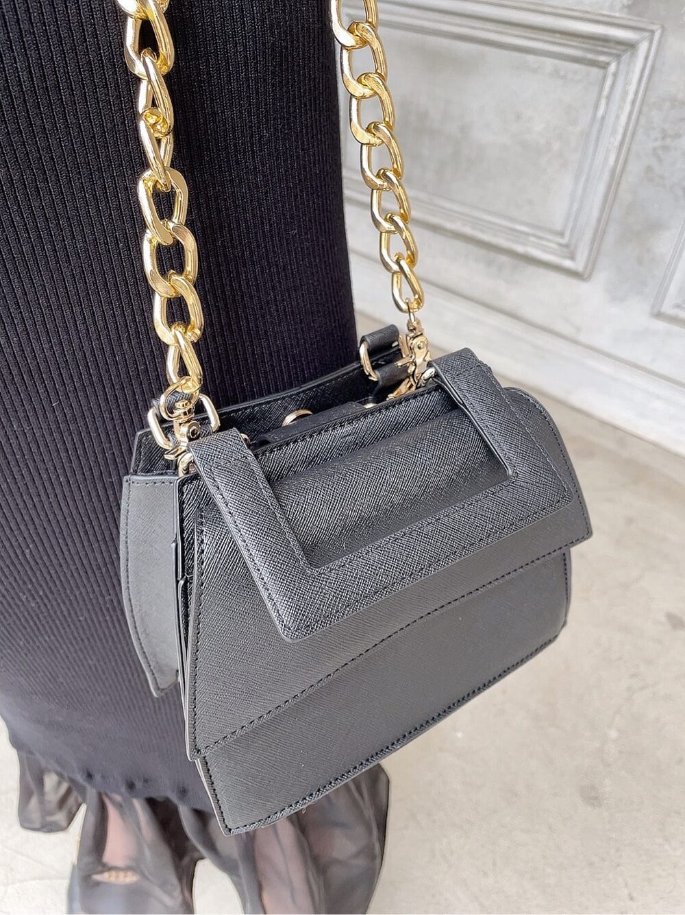 ブラック系のワンピース、ブラック系のサンダル、ブラック系のショルダーバッグを着用したレディースの春コーディネートの9枚目の写真