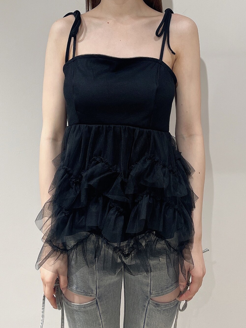 ブラック系のキャミソール、ブルー系のデニムパンツ、ベージュ系のサンダルを着用したレディースの夏コーディネートの5枚目の写真