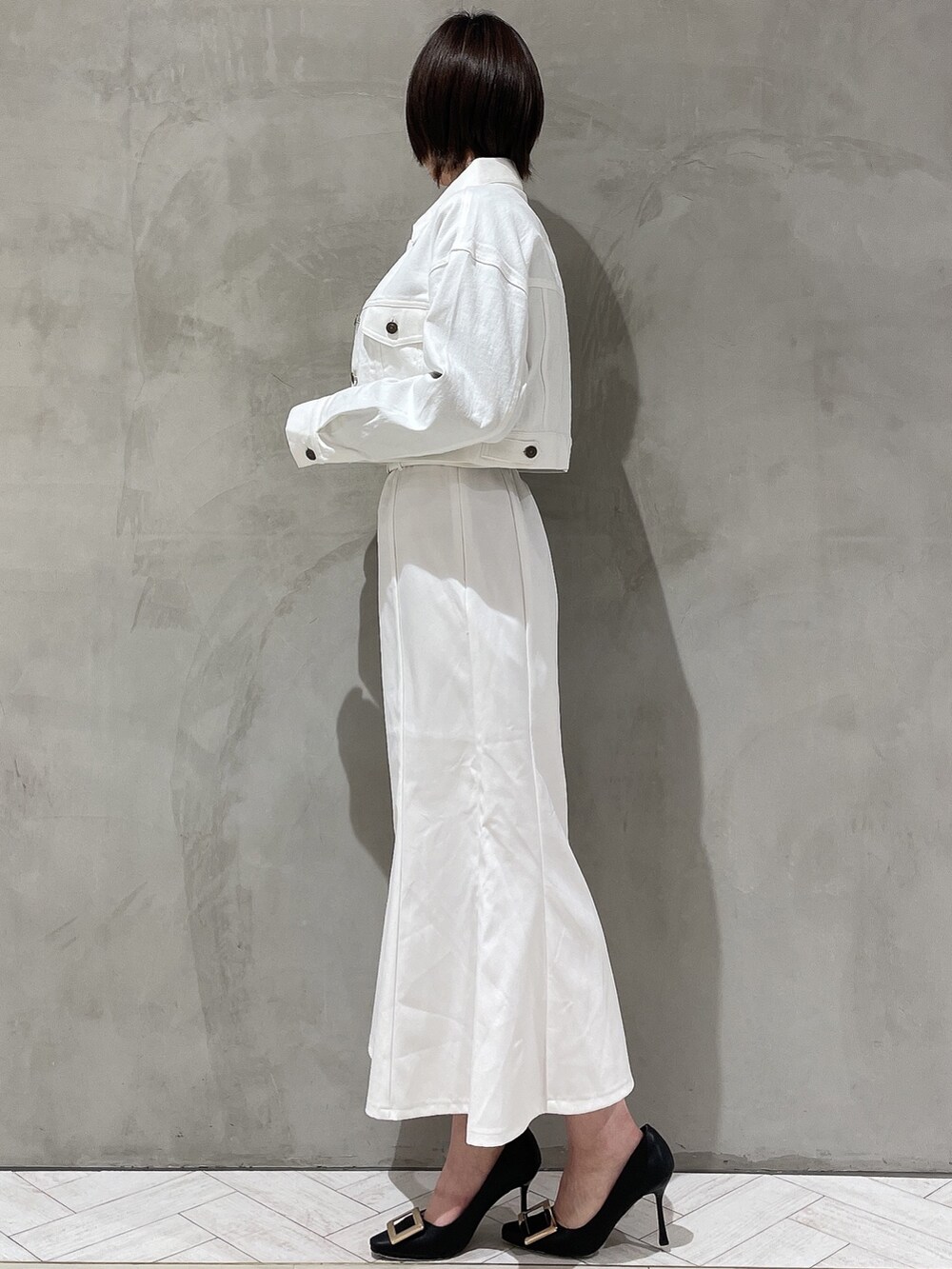 ブラック系のパンプス、ブラック系のニット/セーター、ホワイト系のデニムジャケットを着用したレディースの冬コーディネートの3枚目の写真