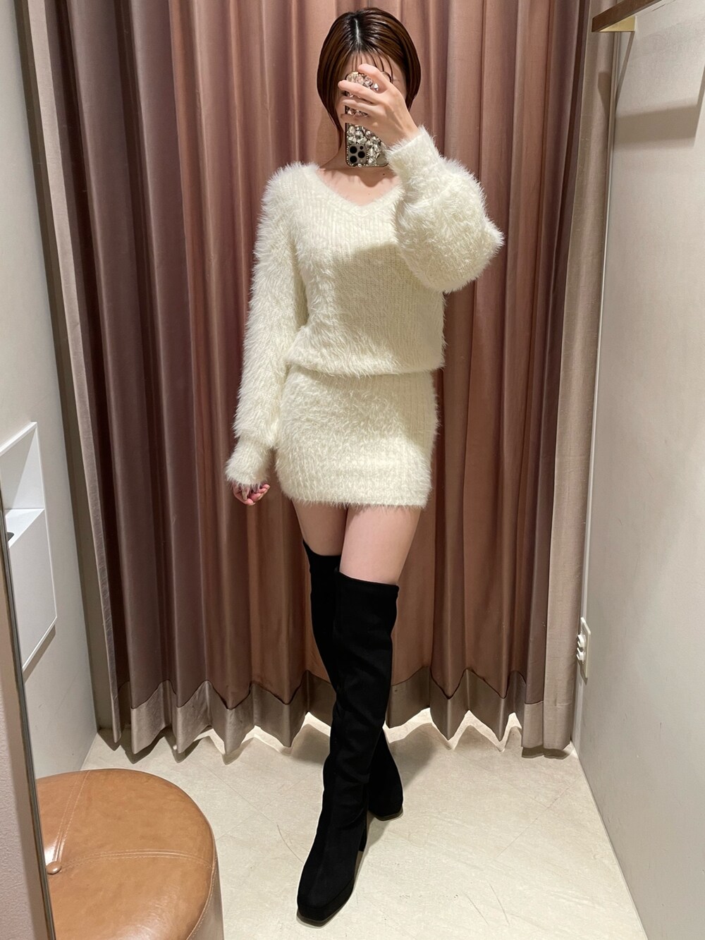 ホワイト系のワンピース、ブラック系のブーツを着用したレディースの秋コーディネートの2枚目の写真