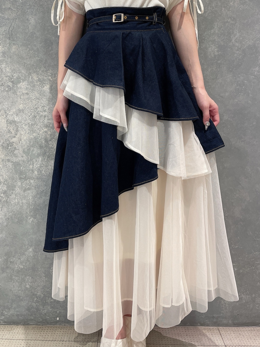 ホワイト系のTシャツ/カットソー、ブルー系のデニムスカート、ホワイト系のサンダルを着用したレディースの夏コーディネートの5枚目の写真