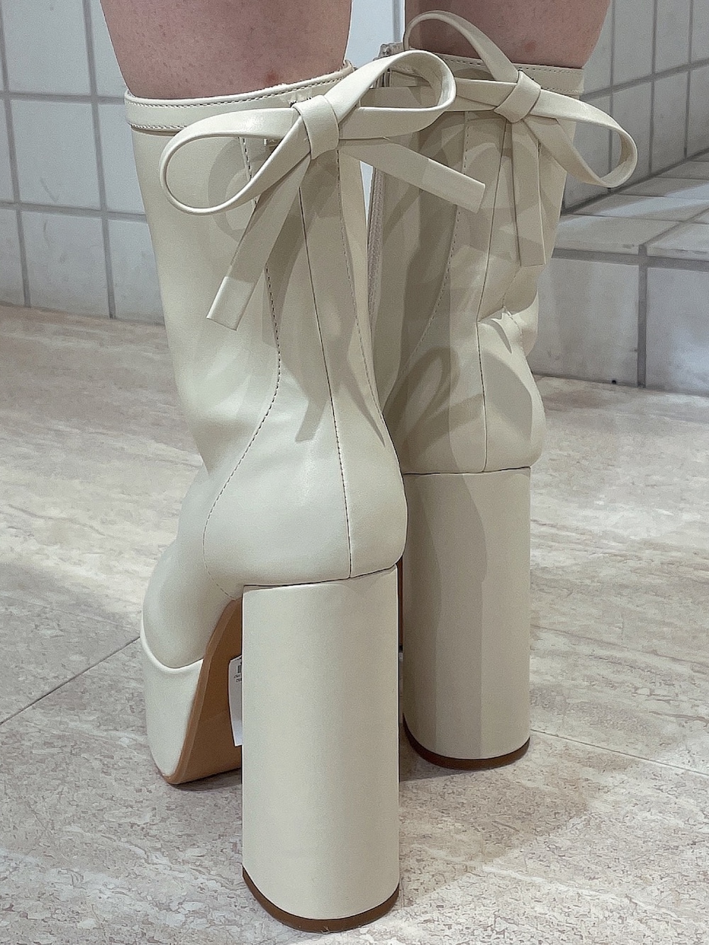 ブルー系のワンピース、ホワイト系のショルダーバッグ、ホワイト系のブーツを着用したレディースの冬コーディネートの8枚目の写真