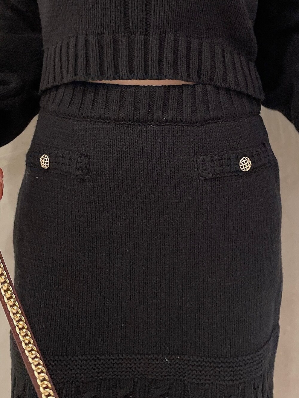 ブラウン系のハンドバッグ、ブラック系のブーツ、ブラック系のニット/セーターを着用したレディースの秋コーディネートの8枚目の写真