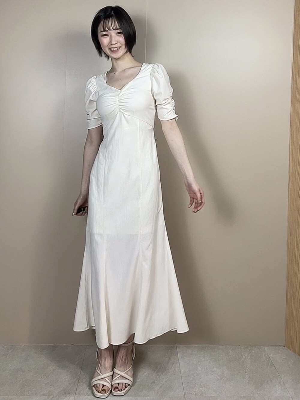 ホワイト系のサンダル、ホワイト系のワンピースを着用したレディースの春コーディネートの2枚目の写真