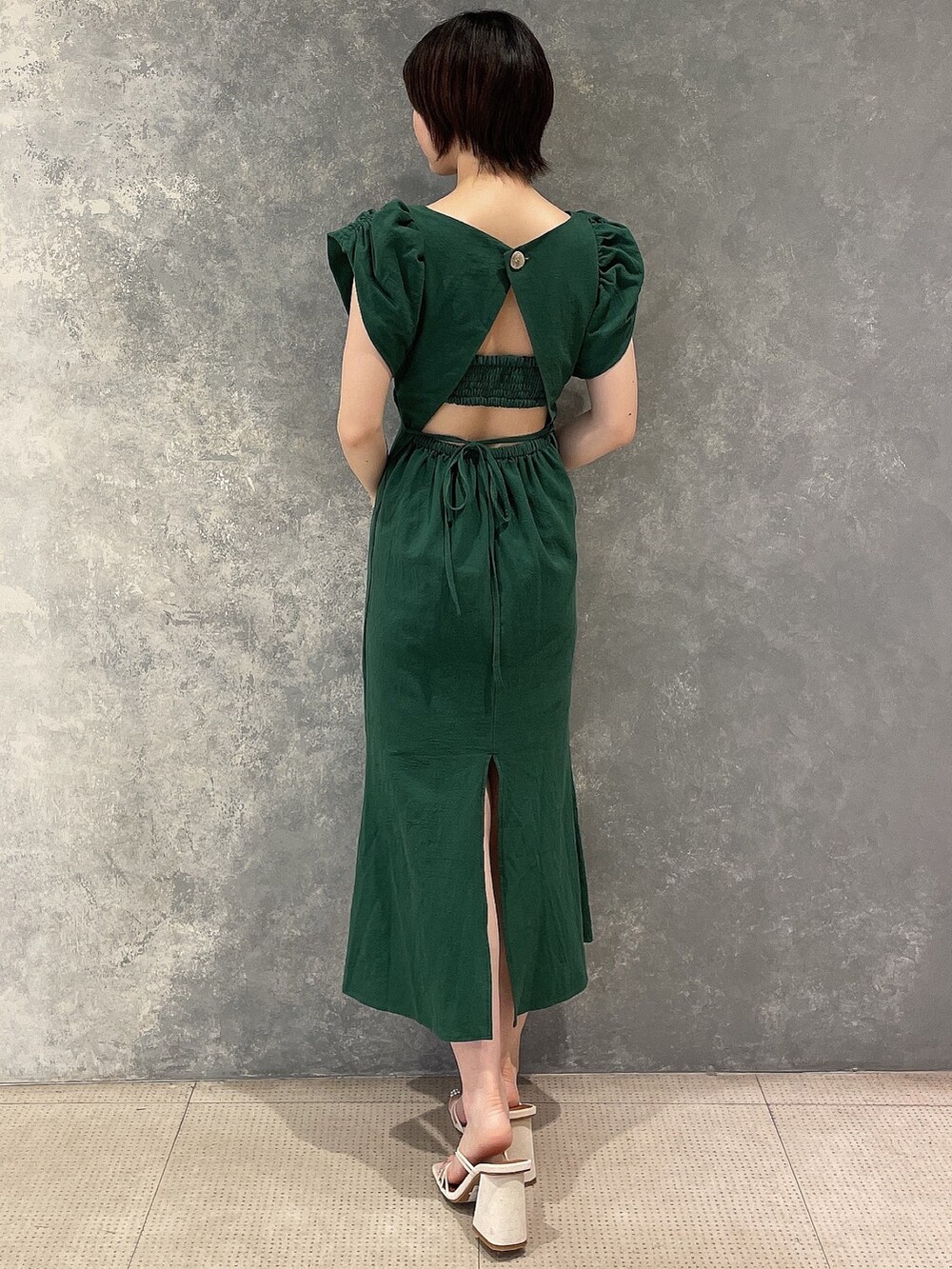 ホワイト系のサンダル、グリーン系のワンピースを着用したレディースの夏コーディネートの3枚目の写真