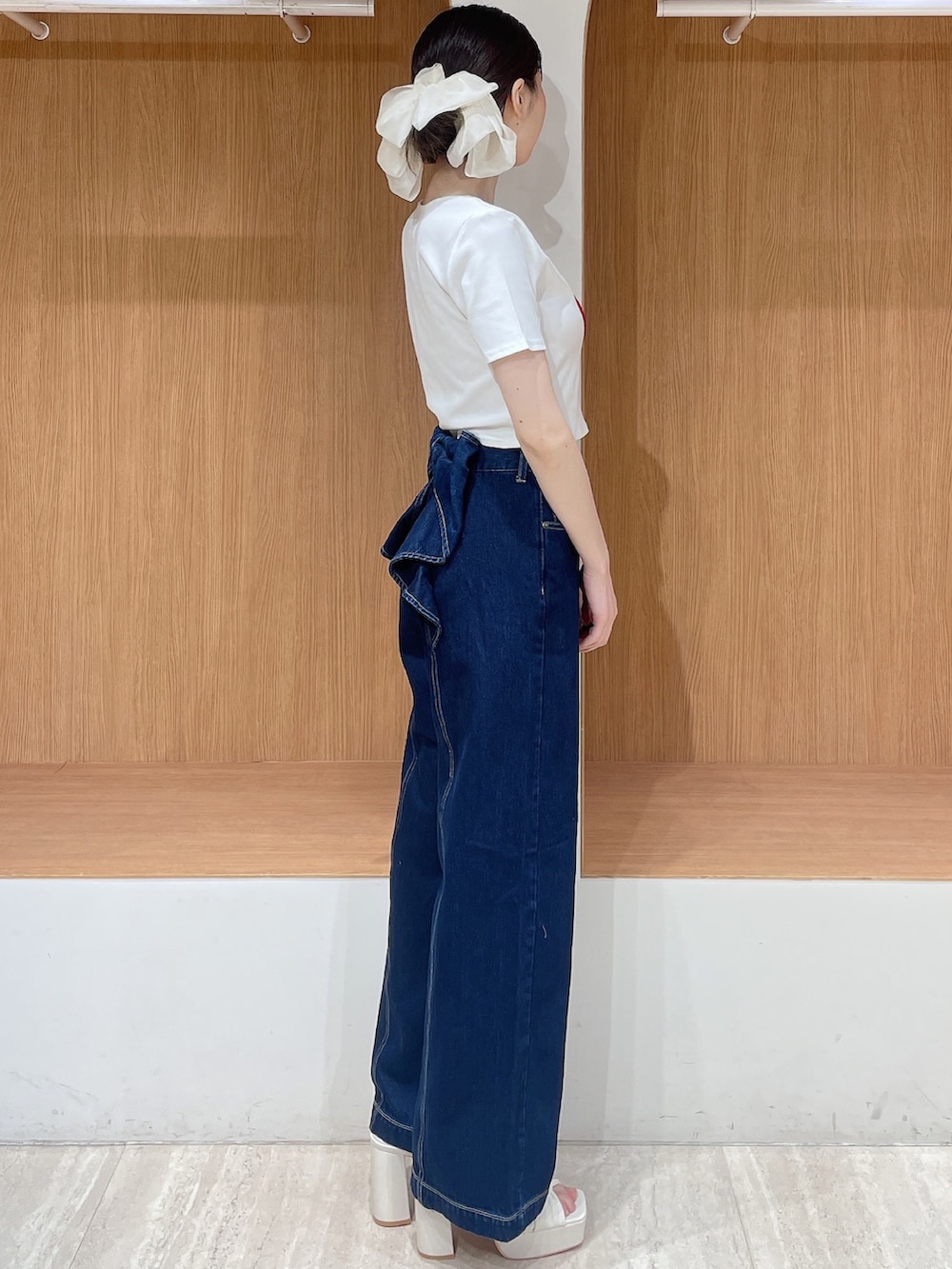 ホワイト系のTシャツ/カットソー、ブルー系のデニムパンツ、ホワイト系のサンダルを着用したレディースの春コーディネートの2枚目の写真