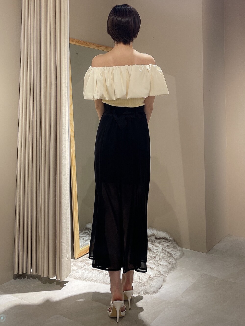 ホワイト系のパンプス、ホワイト系のニット/セーター、ブラック系のスカートを着用したレディースの春コーディネートの4枚目の写真