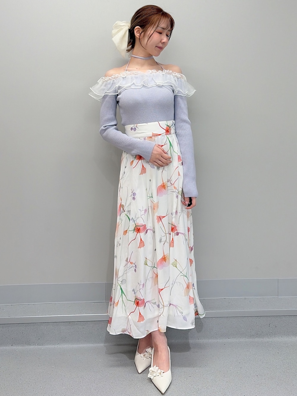 ホワイト系のテーラードジャケット、パープル系のニット/セーター、ホワイト系のスカートを着用したレディースの冬コーディネートの5枚目の写真