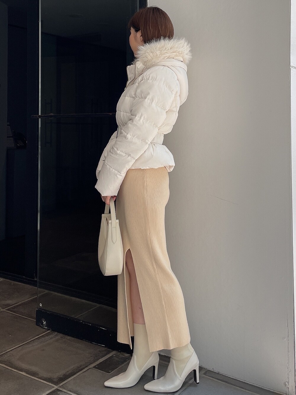 ホワイト系のダウンジャケット/コート、ホワイト系のワンピース、ホワイト系のブーツを着用したレディースの秋コーディネートの3枚目の写真