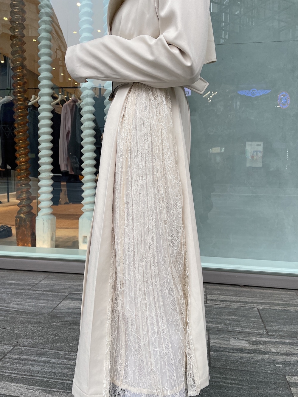 ブラウン系のハンドバッグ、ホワイト系のトレンチコート、ホワイト系のブーツを着用したレディースの冬コーディネートの5枚目の写真