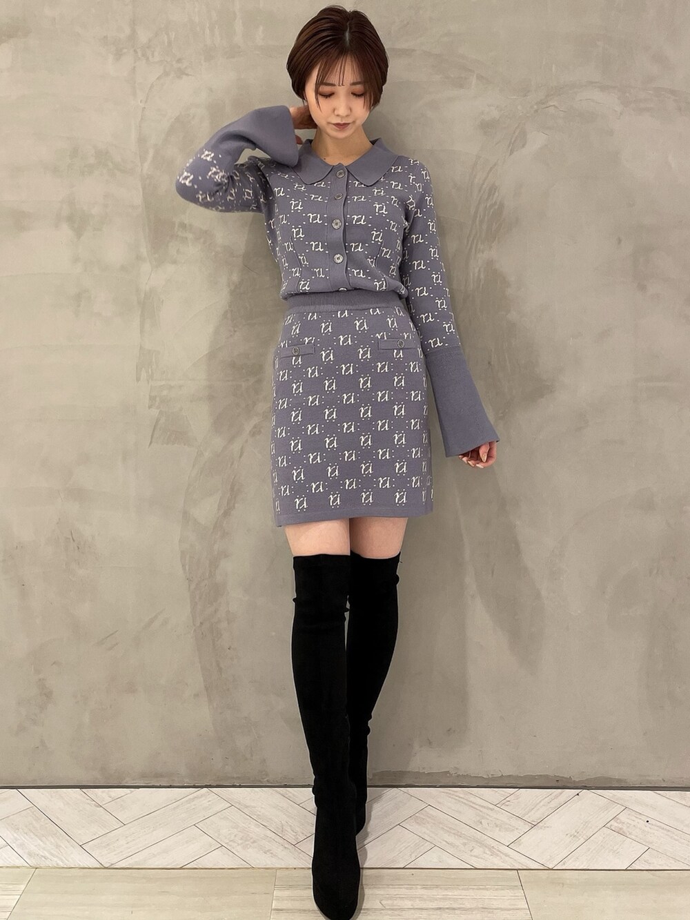 ブラック系のブーツ、ブルー系のニット/セーター、ブルー系のスカートを着用したレディースの冬コーディネートの2枚目の写真