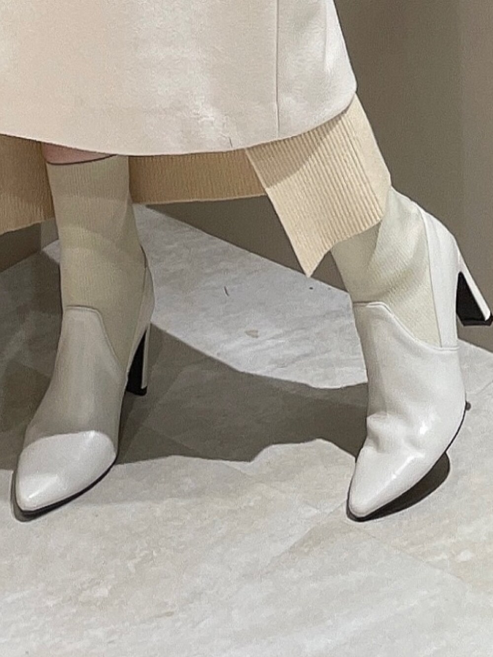 ホワイト系のダウンジャケット/コート、ホワイト系のワンピース、ホワイト系のブーツを着用したレディースの秋コーディネートの7枚目の写真