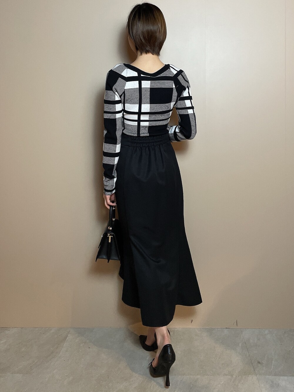 その他のニット/セーター、ブラック系のスカート、ブラック系のパンプスを着用したレディースの冬コーディネートの4枚目の写真