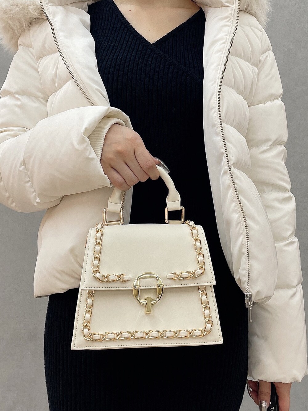 ホワイト系のダウンジャケット/コート、ブラック系のワンピース、ブラック系のブーツを着用したレディースの秋コーディネートの7枚目の写真