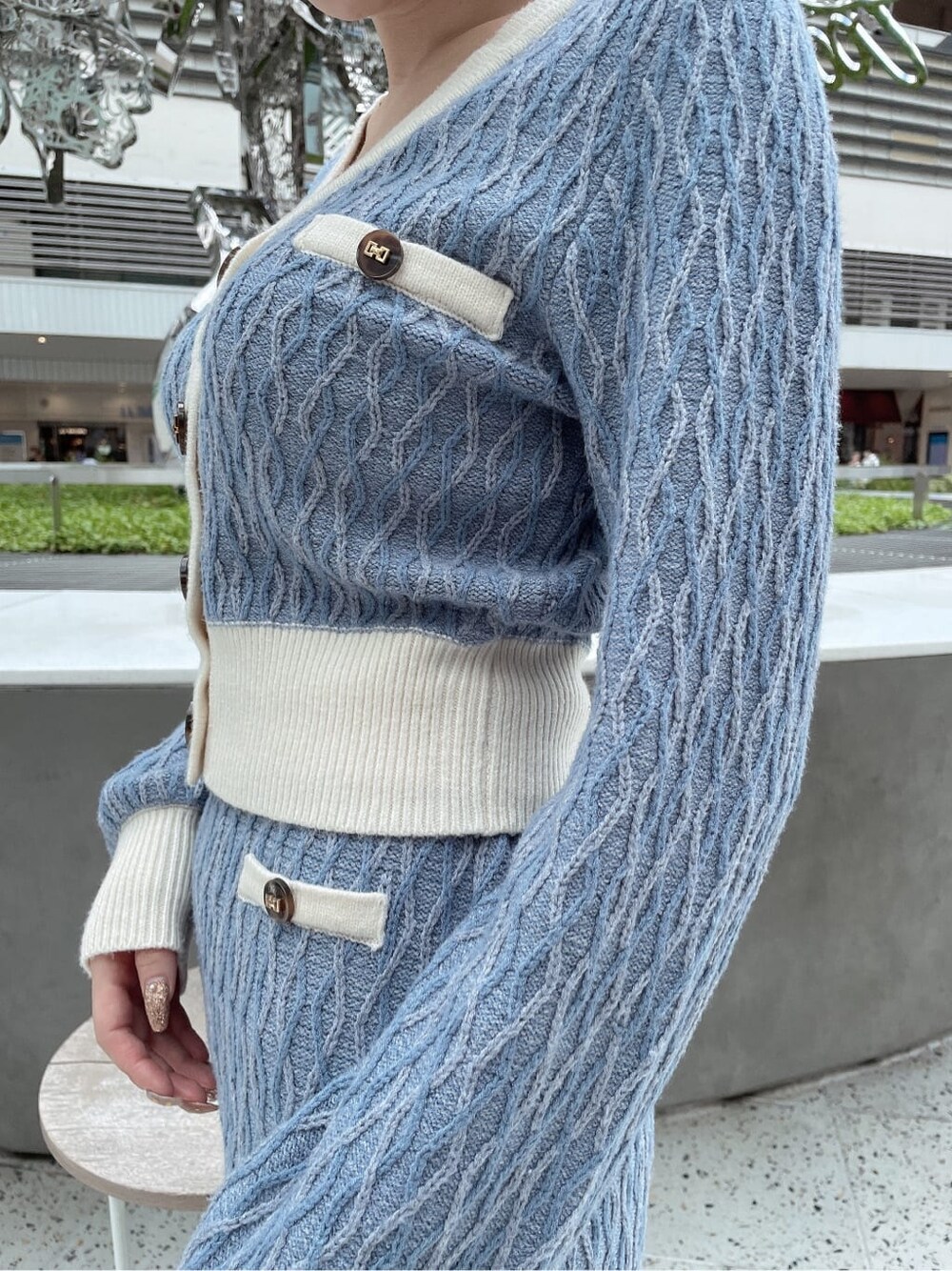 ブルー系のスカート、ブラック系のブーツ、ブルー系のカーディガン/ボレロを着用したレディースの秋コーディネートの6枚目の写真