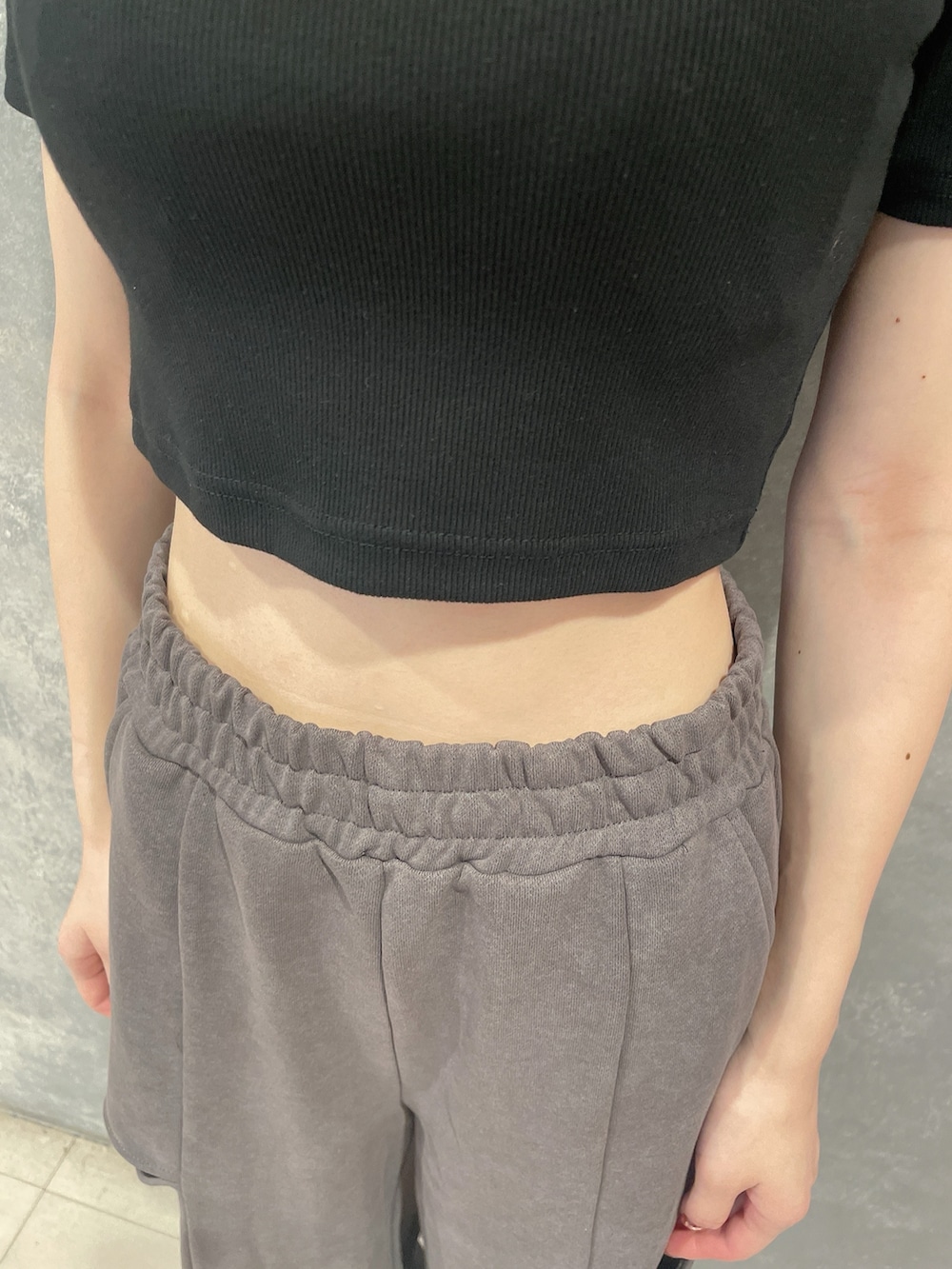 ブラック系のTシャツ/カットソー、グレー系のその他パンツ、ブラック系のパンプスを着用したレディースの夏コーディネートの6枚目の写真