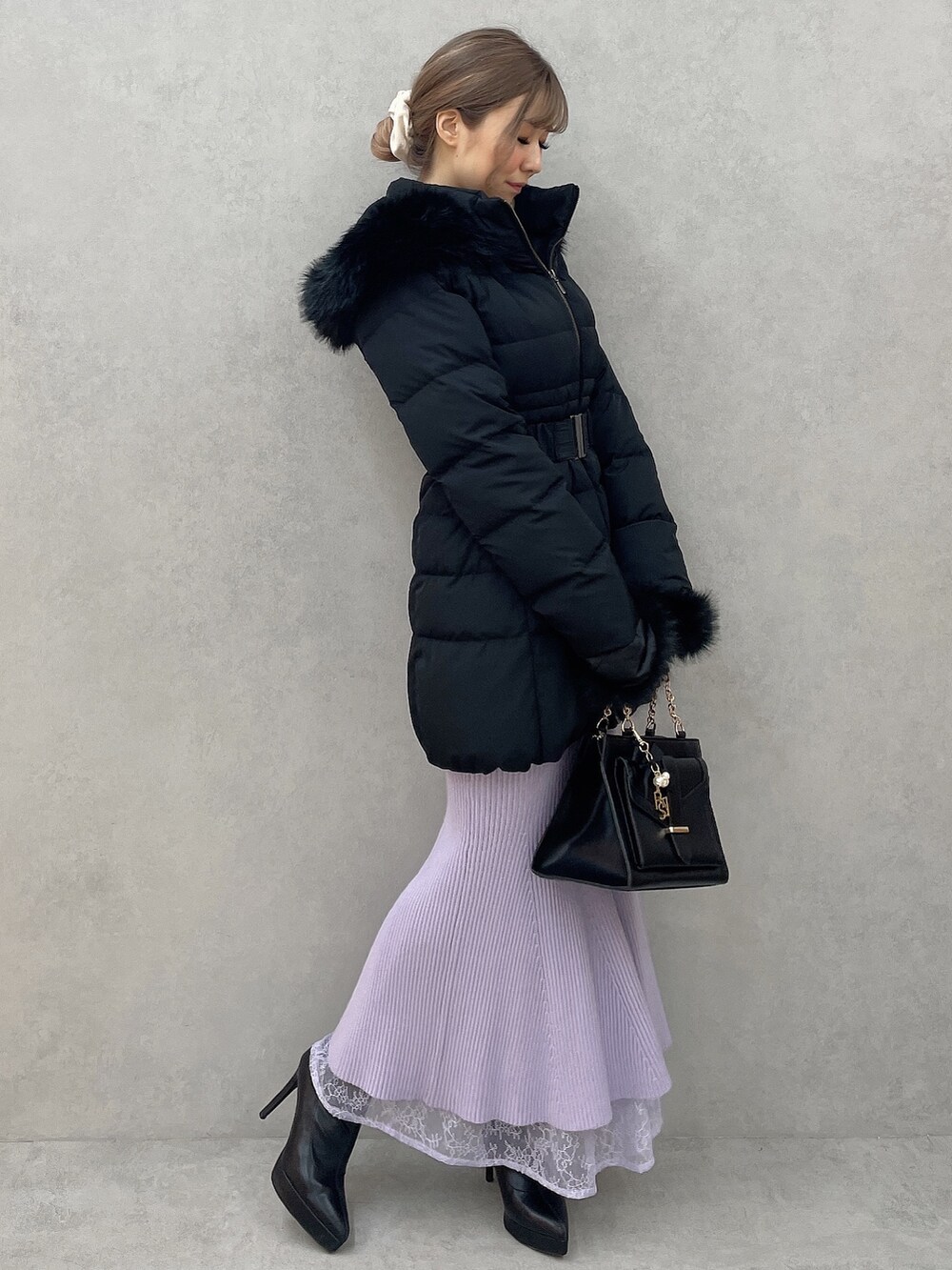 ブラック系のダウンジャケット/コート、パープル系のワンピース、ブラック系のハンドバッグを着用したレディースの秋コーディネートの3枚目の写真