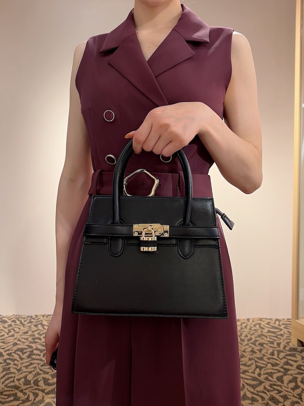 レッド系のワンピース、ブラック系のハンドバッグ、ブラック系のバレッタ/ヘアクリップを着用したレディースの夏コーディネートの5枚目の写真