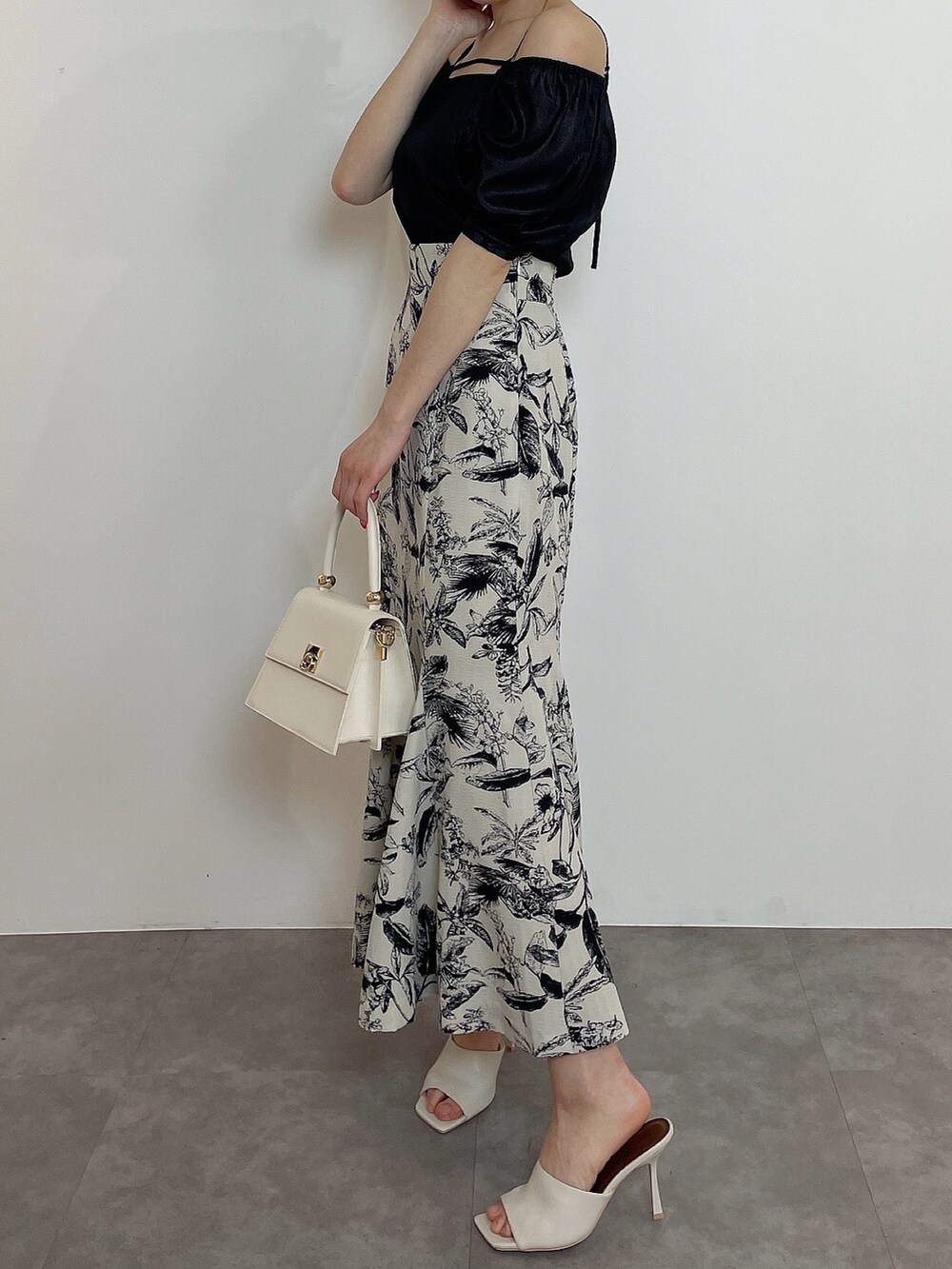 ホワイト系のハンドバッグ、ブラック系のシャツ/ブラウス、その他のスカートを着用したレディースの春コーディネートの2枚目の写真