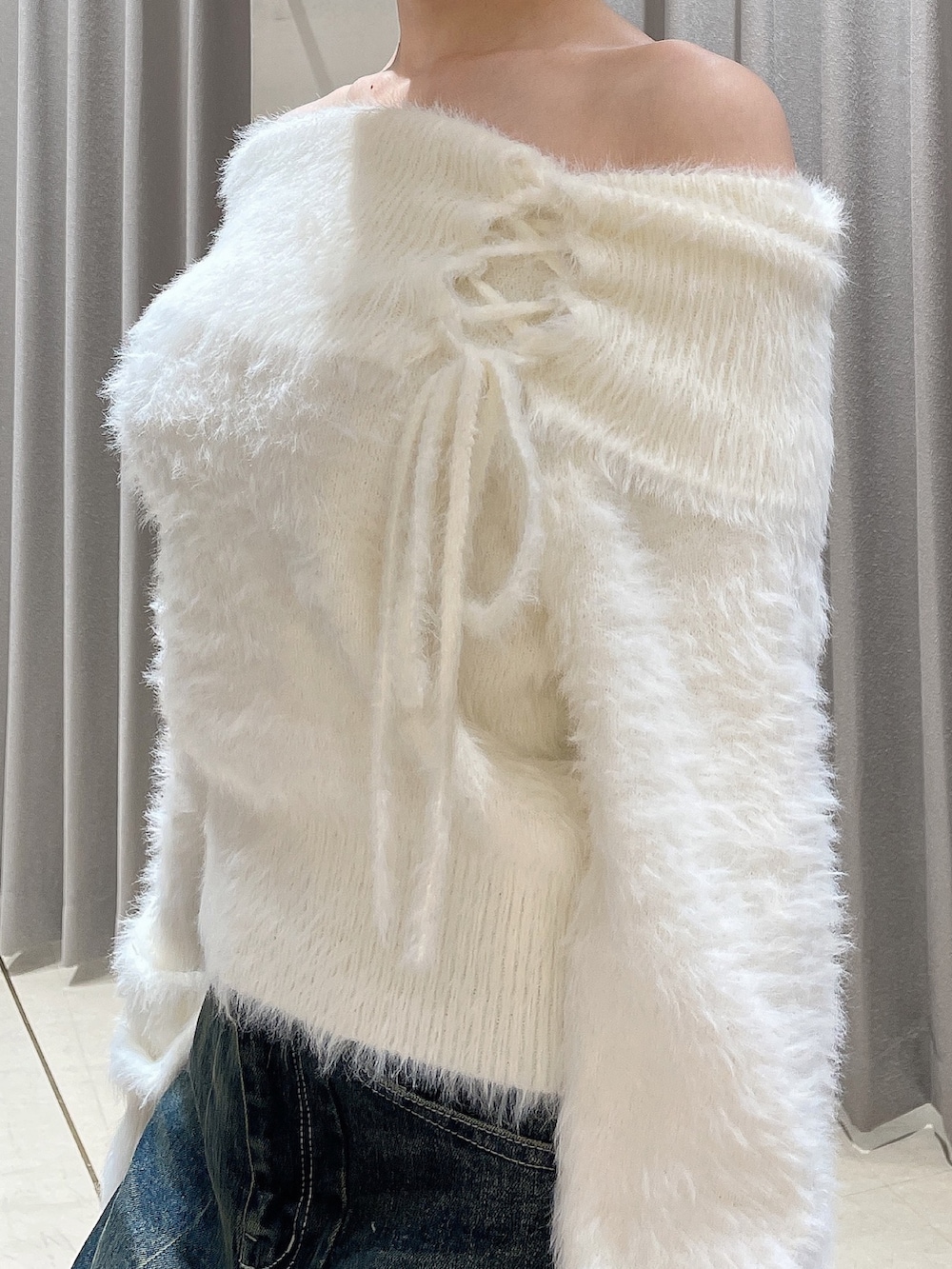 ホワイト系のニット/セーター、ブルー系のデニムパンツ、ブラック系のブーツを着用したレディースの秋コーディネートの6枚目の写真