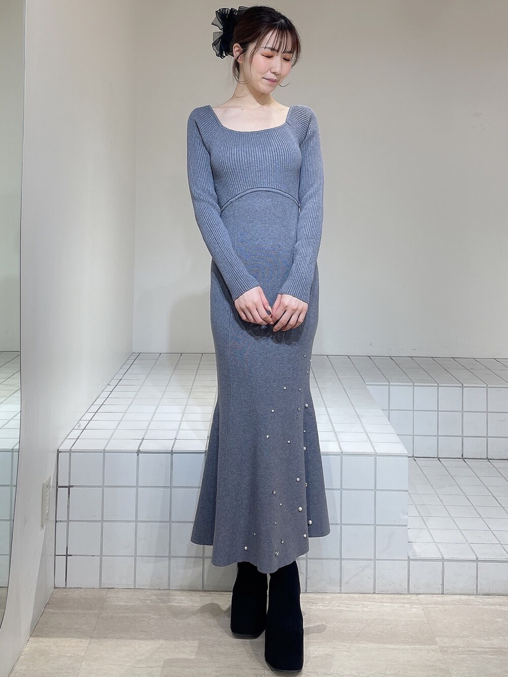 グレー系のワンピース、ブラック系のブーツ、ブラック系のバレッタ/ヘアクリップを着用したレディースの冬コーディネートの2枚目の写真