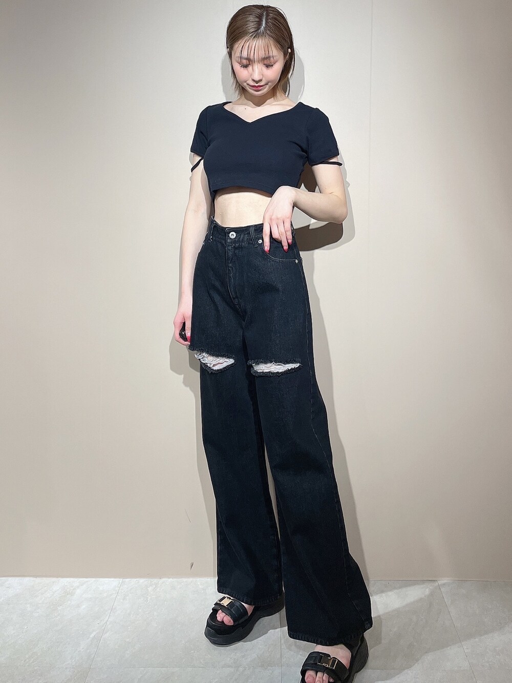 ブラック系のTシャツ/カットソー、ブラック系のデニムパンツ、ブラック系のサンダルを着用したレディースの春コーディネートの2枚目の写真