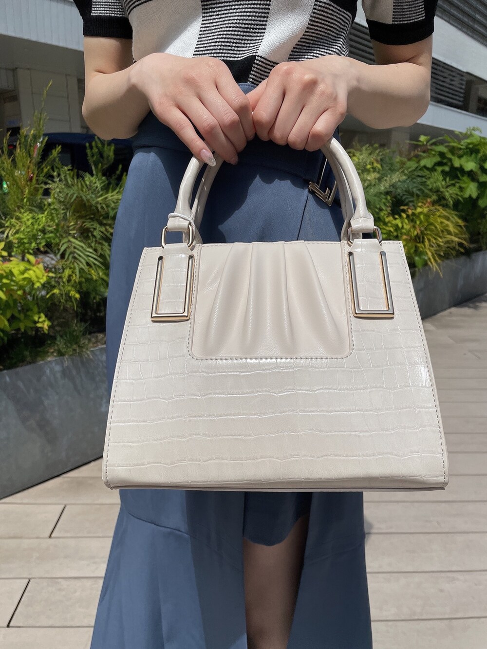 その他のニット/セーター、ブルー系のスカート、ホワイト系のハンドバッグを着用したレディースの春コーディネートの6枚目の写真