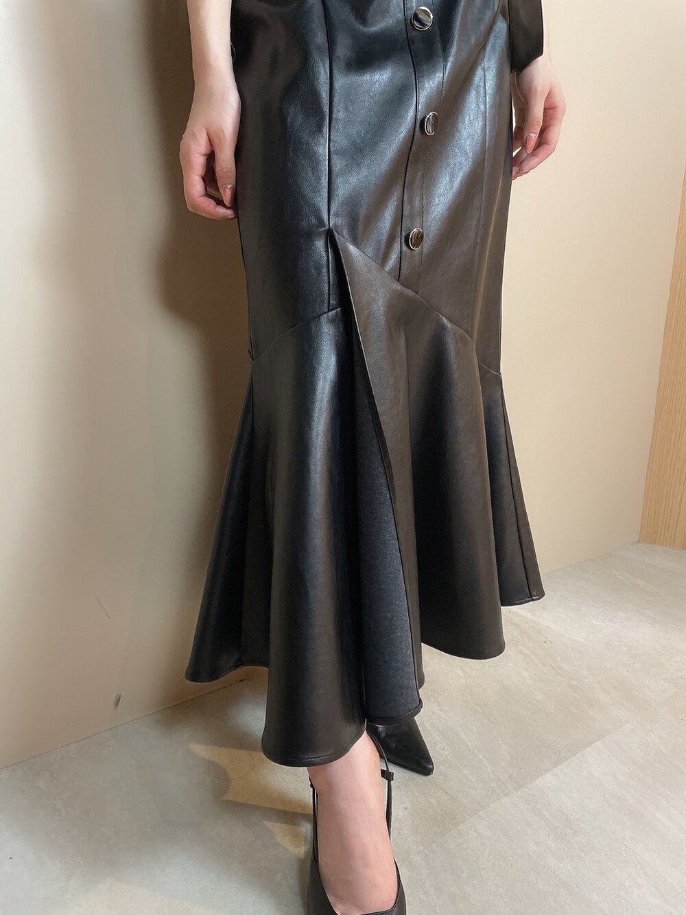 ブラック系のニット/セーター、ブラック系のスカート、ブラック系のサンダルを着用したレディースの夏コーディネートの7枚目の写真