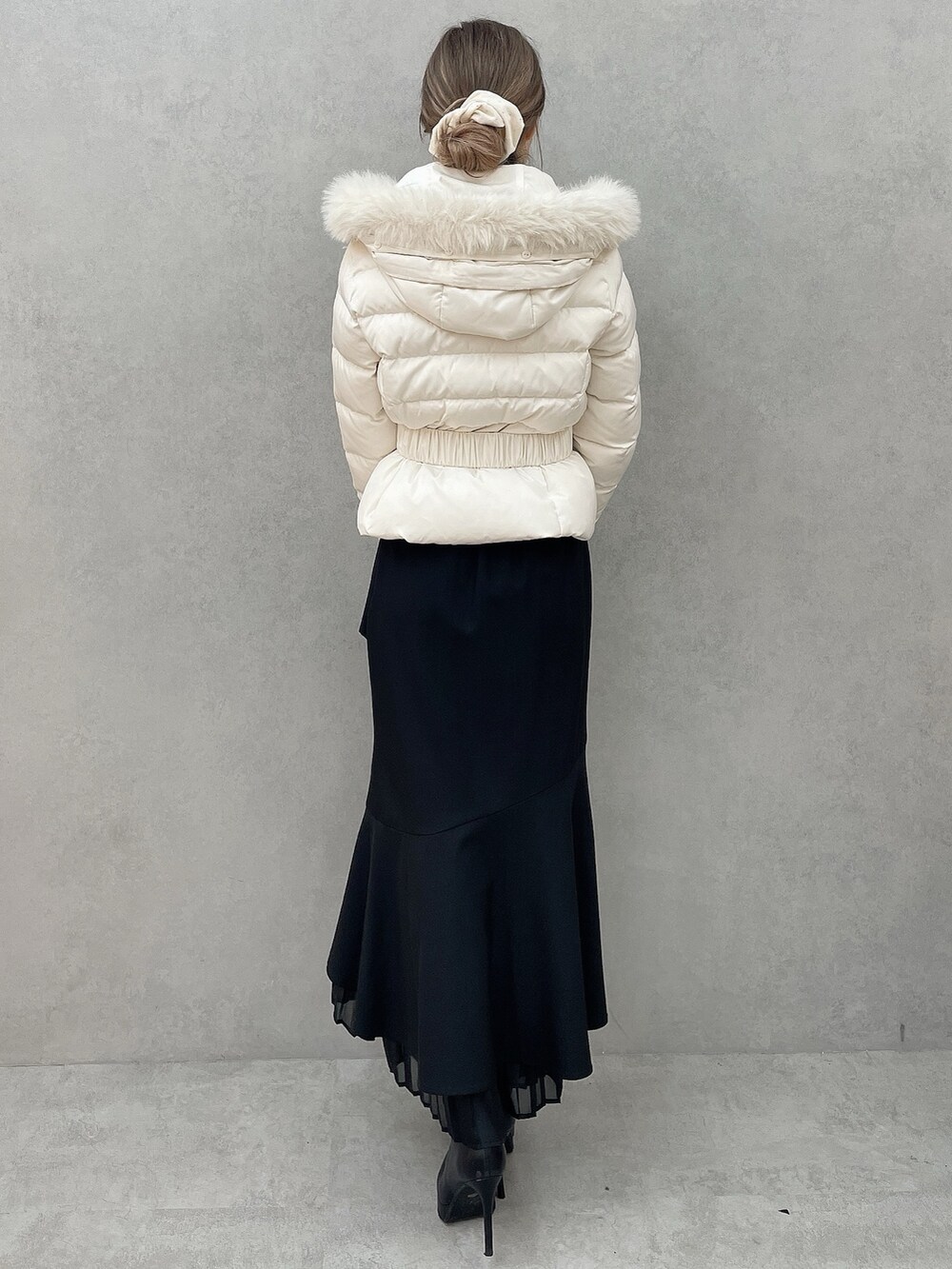 ホワイト系のダウンジャケット/コート、ホワイト系のニット/セーター、ブラック系のスカートを着用したレディースの秋コーディネートの6枚目の写真