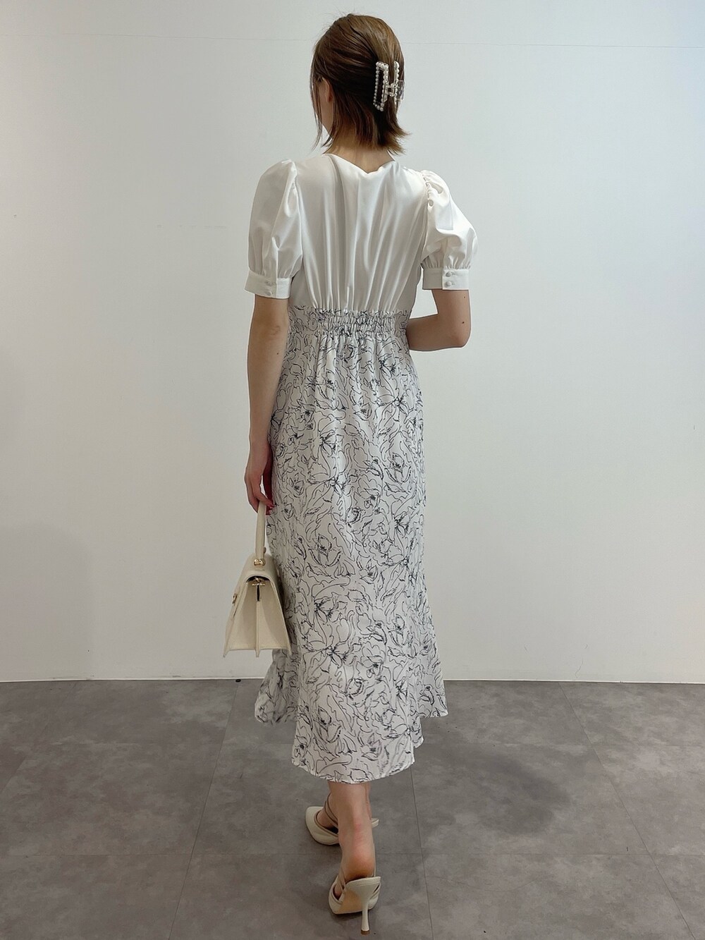 ホワイト系のワンピース、ホワイト系のハンドバッグ、ホワイト系のパンプスを着用したレディースの春コーディネートの4枚目の写真