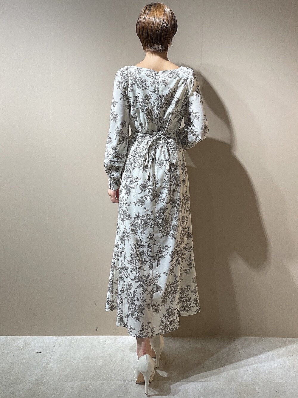 ホワイト系のダウンジャケット/コート、ホワイト系のパンプス、ベージュ系のワンピースを着用したレディースの秋コーディネートの8枚目の写真