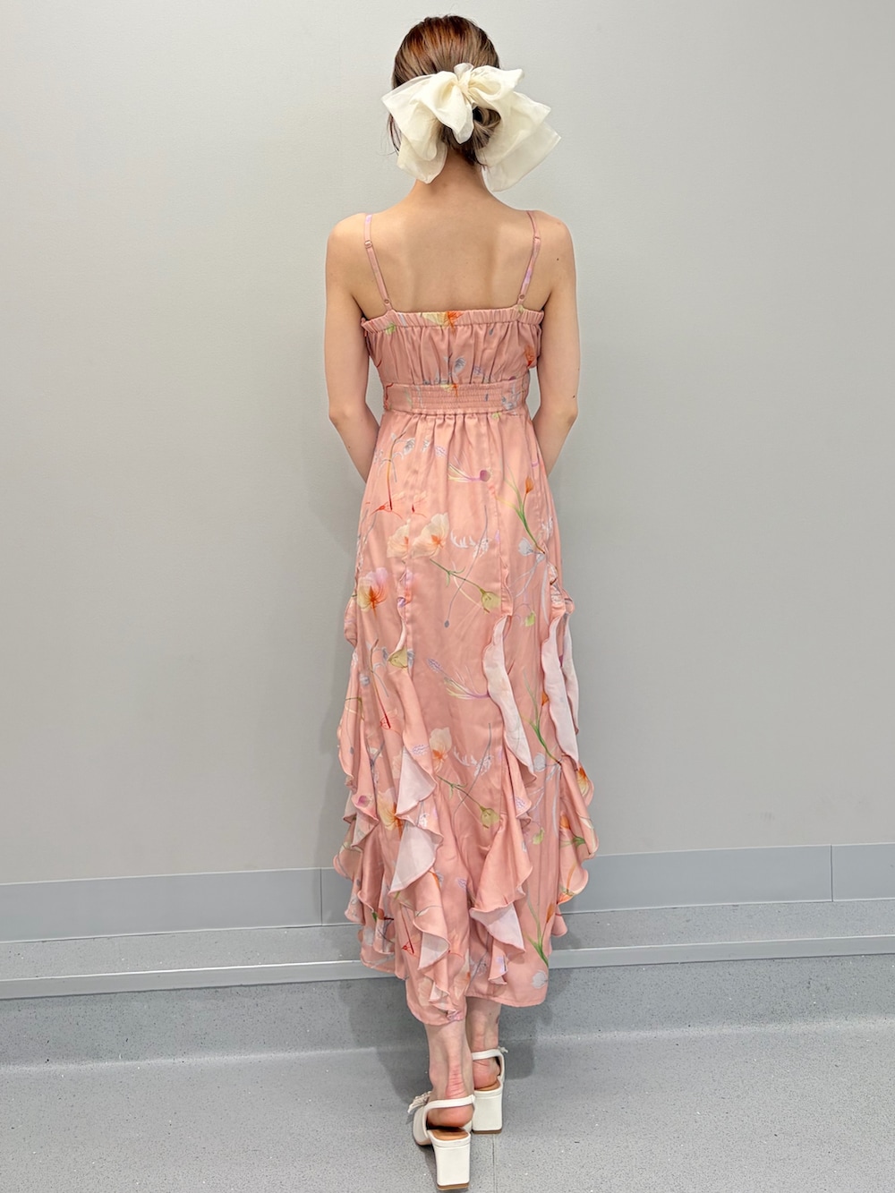 ホワイト系のパンプス、オレンジ系のワンピース、ホワイト系のバレッタ/ヘアクリップを着用したレディースの冬コーディネートの8枚目の写真