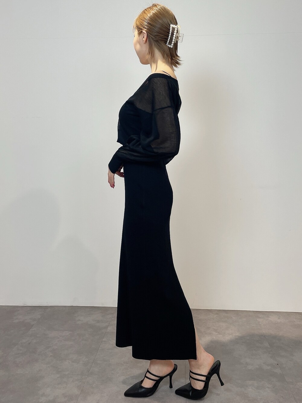 ブラック系のワンピース、ブラック系のパンプスを着用したレディースの冬コーディネートの3枚目の写真