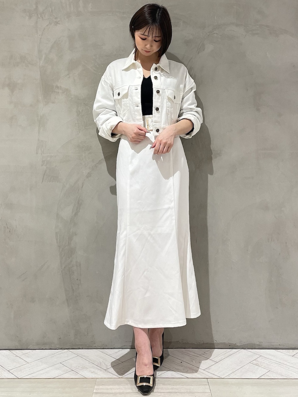 ブラック系のパンプス、ブラック系のニット/セーター、ホワイト系のデニムジャケットを着用したレディースの冬コーディネートの2枚目の写真