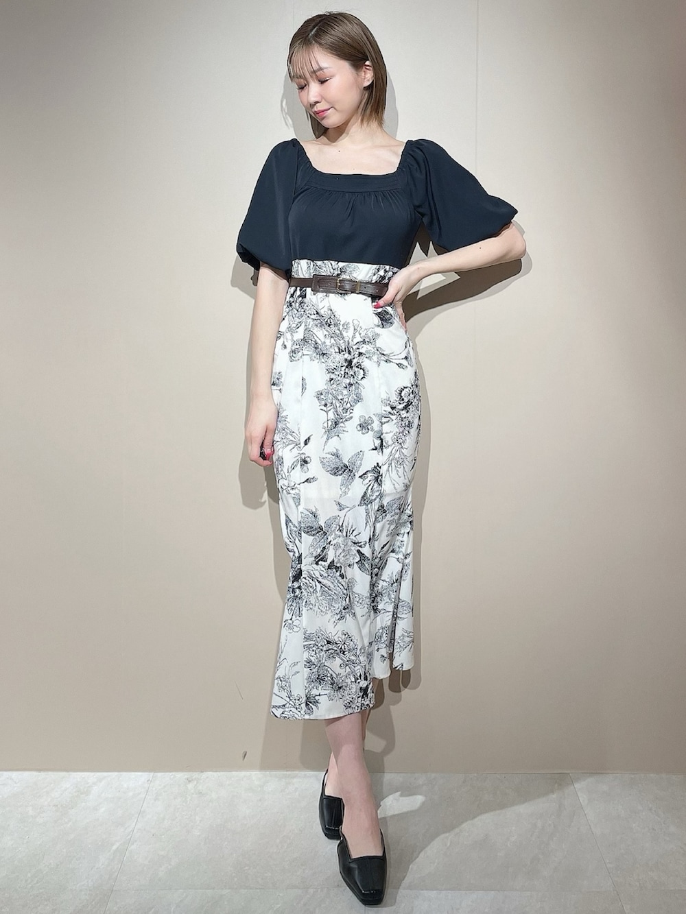 ブラック系のワンピース、ブラック系のパンプス、ブラウン系のベルトを着用したレディースの春コーディネートの3枚目の写真