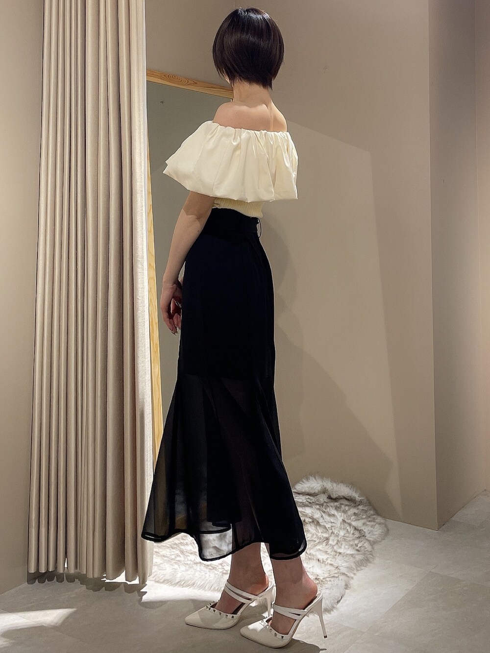 ホワイト系のパンプス、ホワイト系のニット/セーター、ブラック系のスカートを着用したレディースの春コーディネートの3枚目の写真