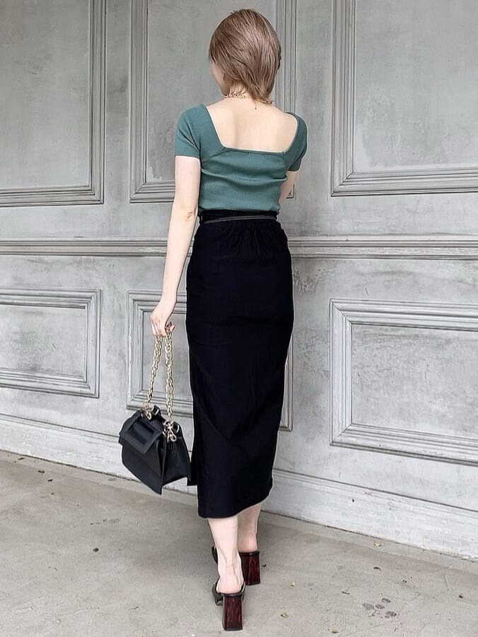 ブラック系のスカート、ブラック系のサンダル、グリーン系のニット/セーターを着用したレディースの春コーディネートの4枚目の写真