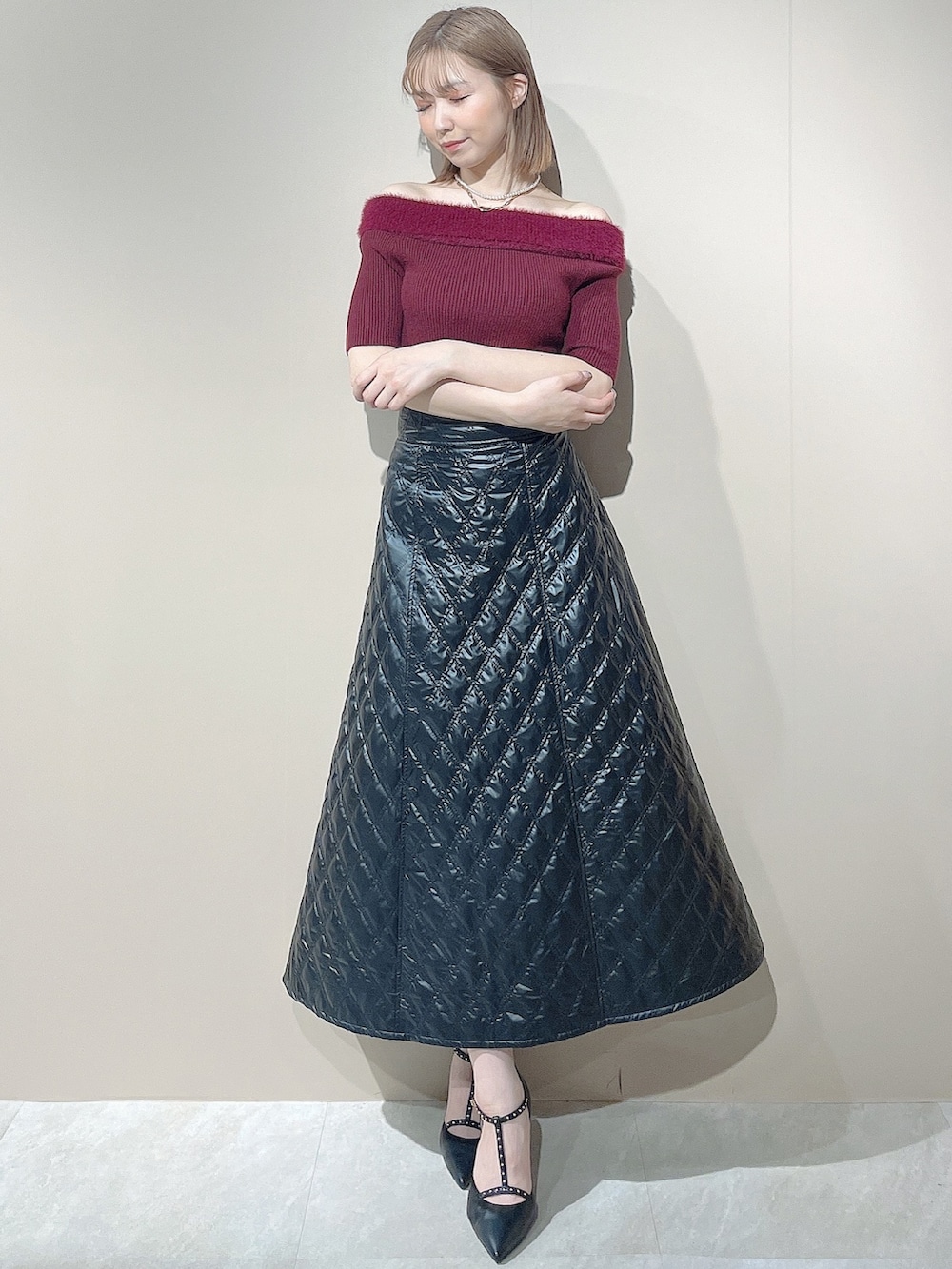 ブラック系のパンプス、レッド系のニット/セーター、ブラック系のスカートを着用したレディースの夏コーディネートの2枚目の写真