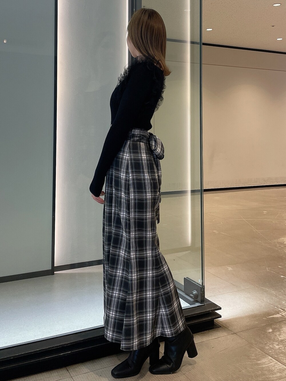 ブラック系のニット/セーター、その他のスカート、ブラック系のブーツを着用したレディースの冬コーディネートの3枚目の写真