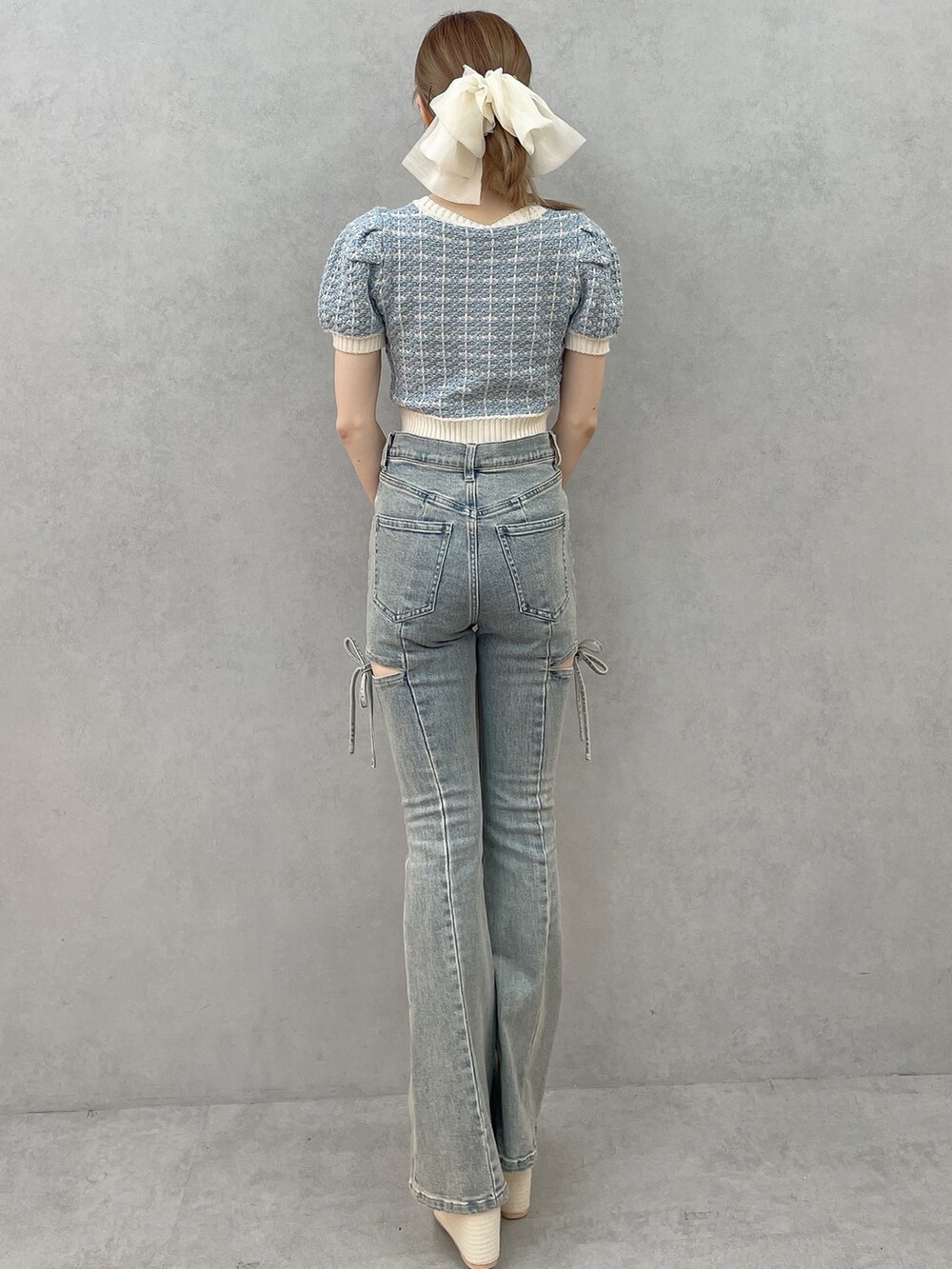 ブルー系のニット/セーター、ホワイト系のハンドバッグ、ホワイト系のサンダルを着用したレディースの春コーディネートの3枚目の写真