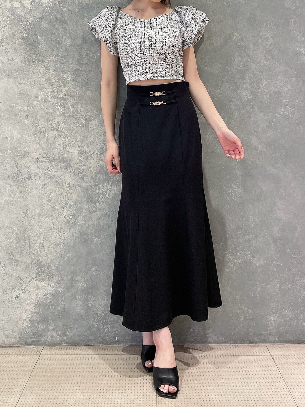 ホワイト系のシャツ/ブラウス、ブラック系のスカート、ブラック系のサンダルを着用したレディースの夏コーディネートの2枚目の写真