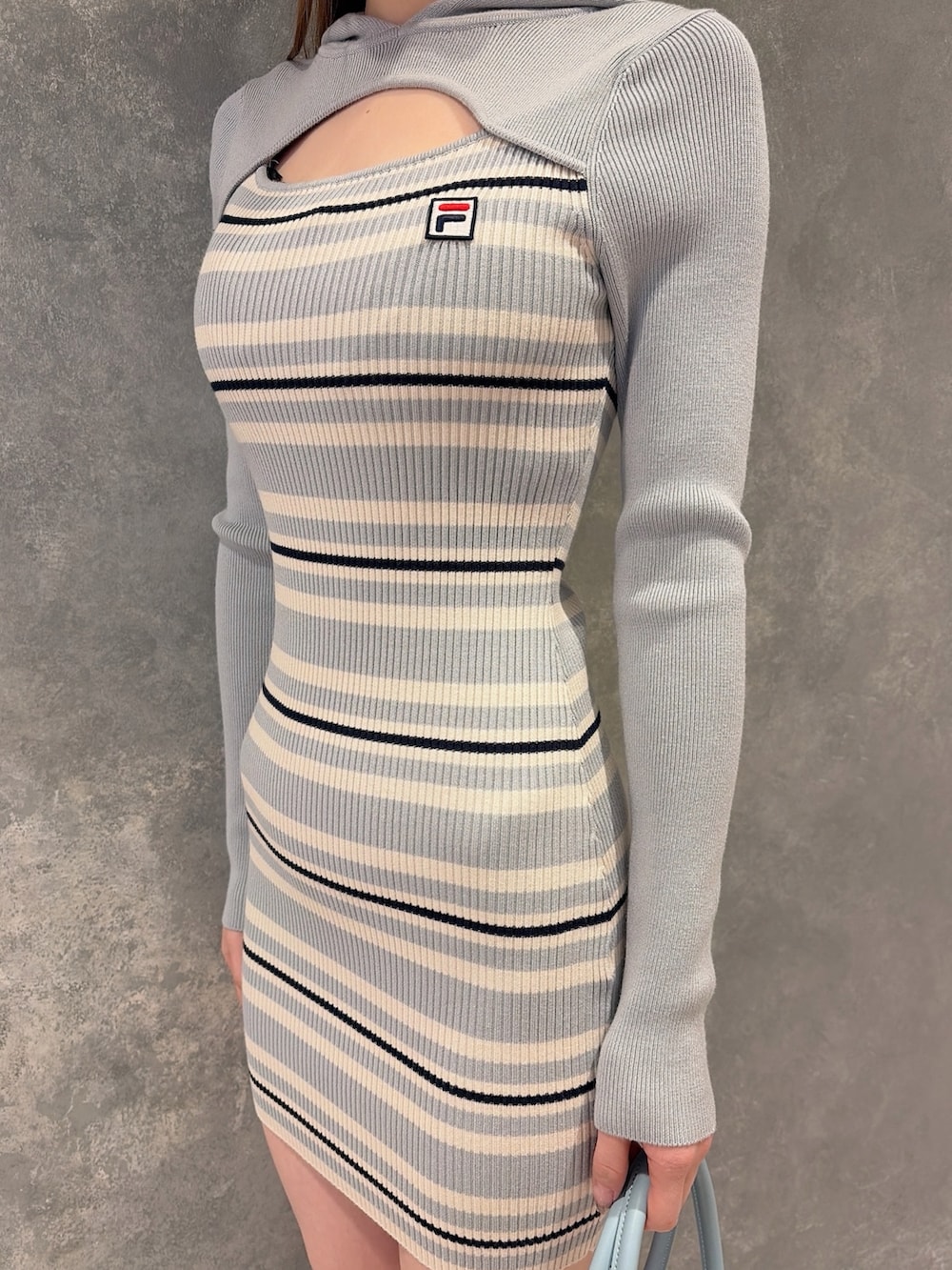 ホワイト系のブーツ、ブルー系のボストンバッグ、ブルー系のワンピースを着用したレディースの冬コーディネートの5枚目の写真