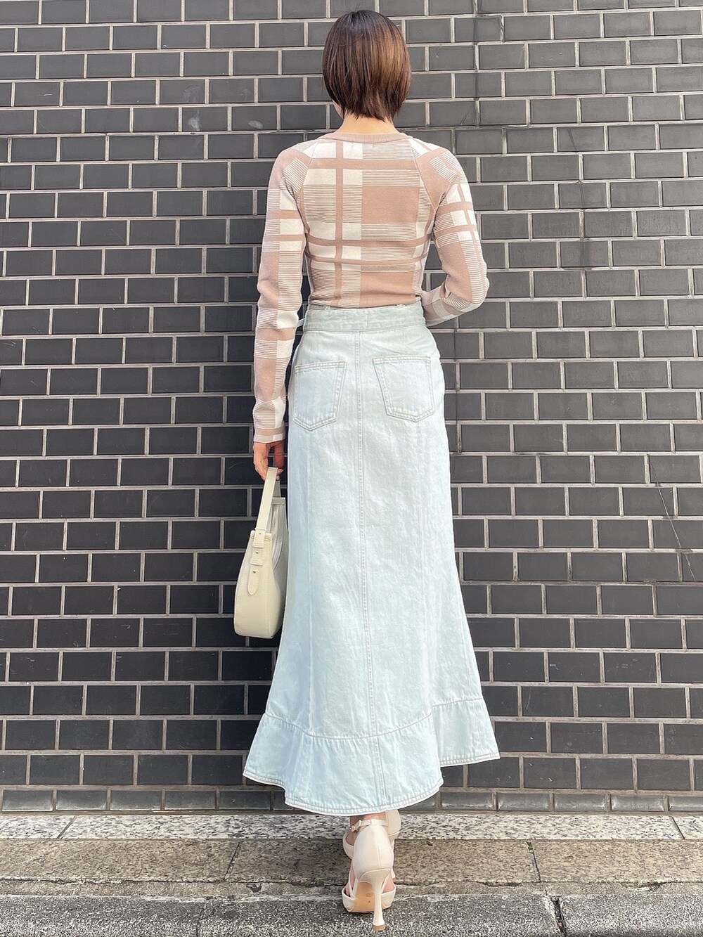 その他のニット/セーター、ホワイト系のハンドバッグ、ブルー系のデニムスカートを着用したレディースの冬コーディネートの5枚目の写真