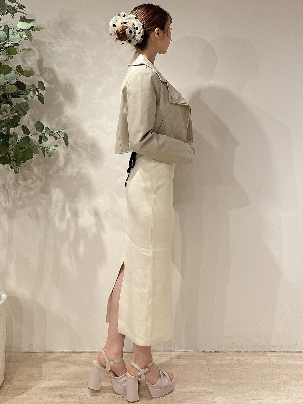 ホワイト系のライダースジャケット、ホワイト系のワンピース、ベージュ系のサンダルを着用したレディースの春コーディネートの2枚目の写真