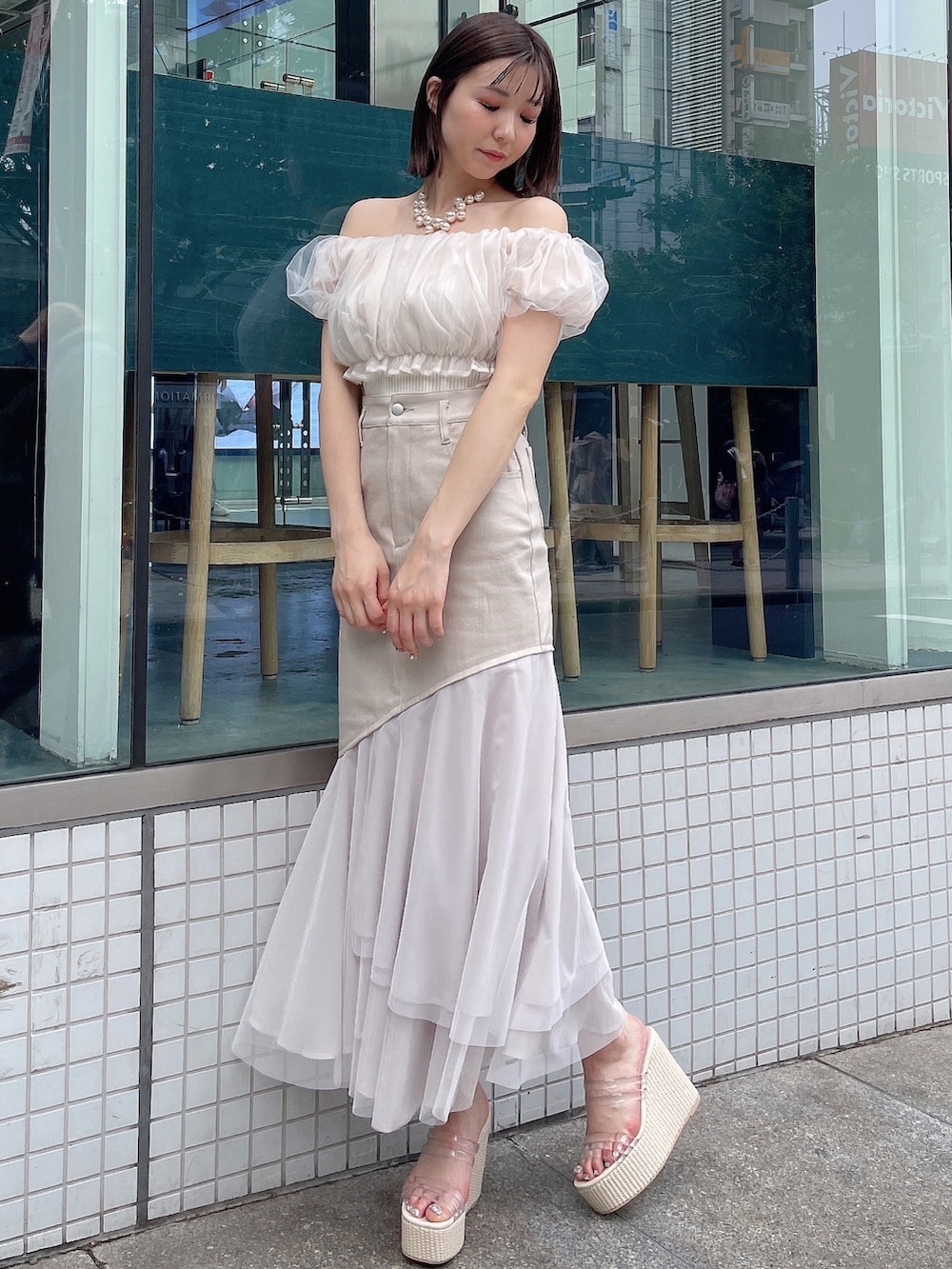 ホワイト系のシャツ/ブラウス、ベージュ系のスカート、ホワイト系のサンダルを着用したレディースの春コーディネートの3枚目の写真