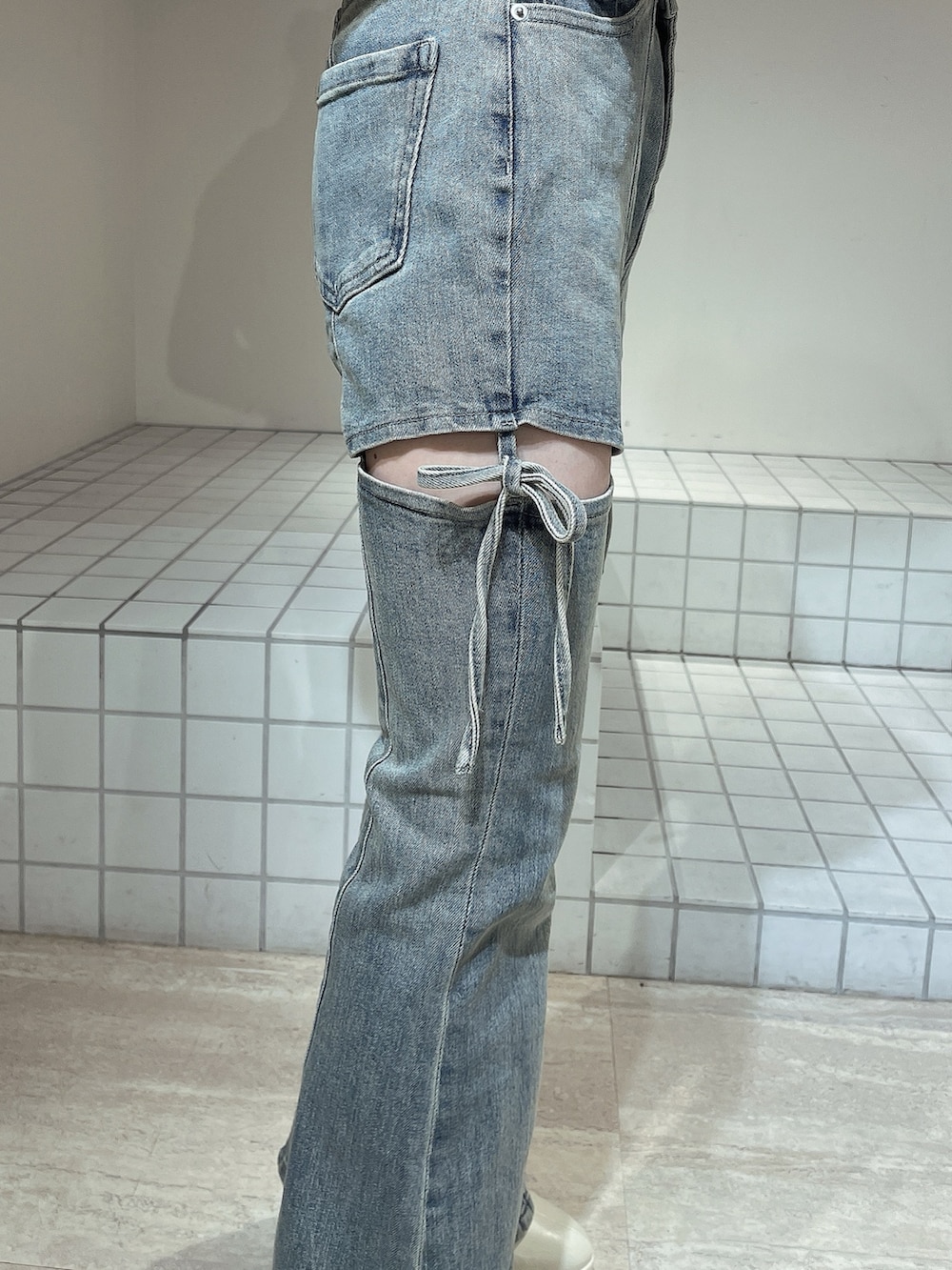 ブラック系のニット/セーター、ブルー系のデニムパンツ、ホワイト系のブーツを着用したレディースの冬コーディネートの6枚目の写真