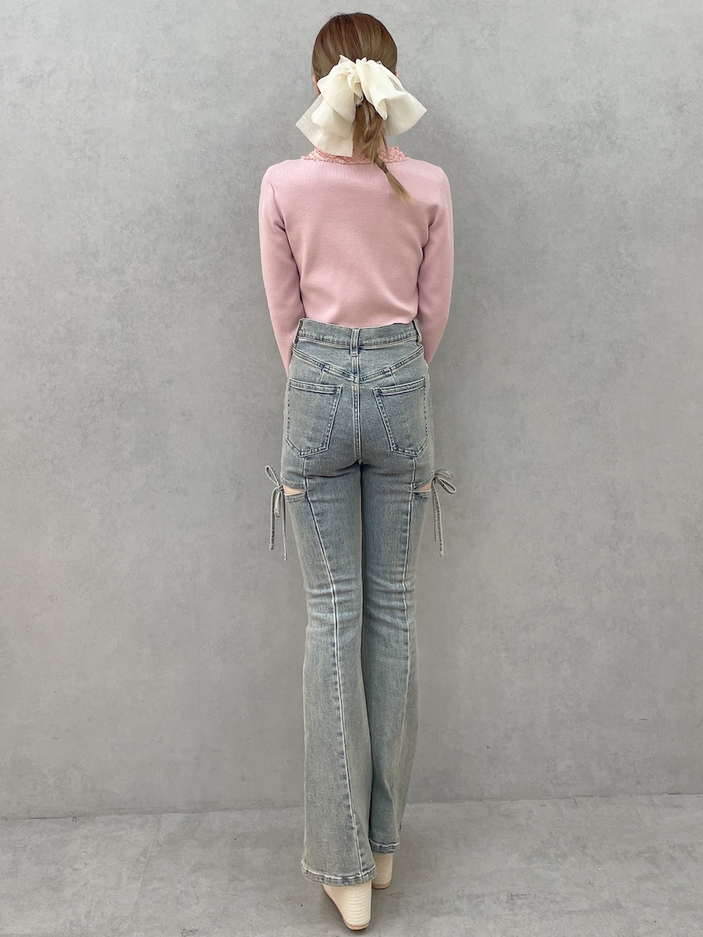 ピンク系のニット/セーター、ブルー系のデニムパンツ、ホワイト系のサンダルを着用したレディースの春コーディネートの4枚目の写真