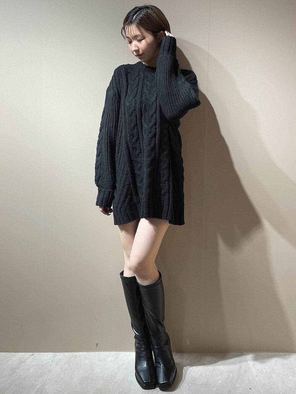 ブラック系のニット/セーター、グレー系のチェスターコート、ブラック系のブーツを着用したレディースの秋コーディネートの5枚目の写真